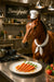 Humorous artwork of a horse chef proudly presenting gourmet carrots in a stylish kitchen titled Boneighpetit
