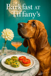 Bloodhound looking up at a crystal chandelier behind a marble table set with three spinach quiche bites, two tomato bruschetta slices, a peach cocktail, and a white dahlia in a vase