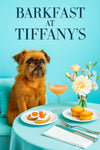 Scruffy Brussels Griffon on a turquoise banquette with ricotta crostini topped with cherry tomatoes, two mini muffins, a peach-hued cocktail and ranunculus bouquet under “Barkfast at Tiffany’s” sign