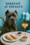 Regal Cane Corso seated before a Tiffany-blue banquette and marble table topped with ham-and-brie crostini, fruit preserves, apricot jam ramekins, and a peach cocktail under “Barkfast at Tiffany’s” title