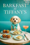 Cavachon dog in a turquoise bow tie seated at a posh brunch table with muffins, tea sandwiches and a cocktail