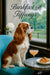 Cavalier King Charles Spaniel on a turquoise chair by a window with a croissant and peach cocktail on a metal table beneath Barkfast at Tiffany’s lettering