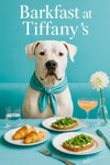 Dogo Argentino wearing turquoise scarf seated at turquoise booth with cheese-topped croissants, arugula toasts, glass of water, frothy cocktail, and white flower in vase