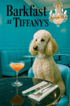 Cream poodle wearing a rhinestone collar seated at a black marble café table with a coral cocktail and silverware teal banquette and chandelier metal print