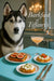 Black-and-white husky with blue eyes next to plates of fig toast cottage cheese toasts and a pink cocktail on a teal table