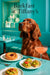 Auburn Irish Setter on teal banquette beside a strawberry swirl pastry guacamole toasts and pink cocktail
