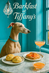 Italian Greyhound with turquoise collar seated at a marble table with sugar-topped scones smoked salmon toast pink cocktail and a small bowl of citrus juice