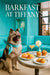 Fluffy Keeshond wearing a teal scarf seated beside a table with mini ham croissants, muffins, and a pink cocktail against a Tiffany-blue banquette