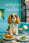 Ruby and white King Charles Cavalier seated on a teal banquette beside fig-topped blueberry muffins, spinach quiche, a pink cocktail, and a dahlia