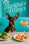 Black-and-tan Miniature Pinscher wearing a silver chain seated at a turquoise banquette with avocado toast topped with arugula, smoked salmon canapé rounds with crème fraîche, and a peach cocktail under a Barkfast at Tiffany’s sign