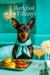 Black-and-tan Miniature Pinscher wearing a turquoise scarf seated at a metal table with mini spinach quiches, tomato bruschetta crostini, a peach cocktail and white dahlia under a Barkfast at Tiffanyâs sign
