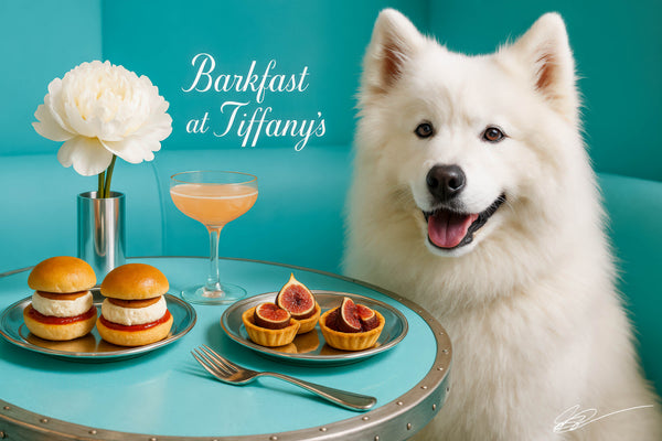 Fluffy Samoyed wearing a turquoise scarf seated on a tufted turquoise banquette beside a round café table with a white peony in a metallic vase