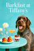 Wirehaired pointing griffon seated next to a teal table with smoked salmon sliders a layered berry parfait a peach cocktail and white flowers in bud vases against a Tiffany-blue banquette