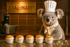 Koala chef in a toque with five soufflés lined up in a modern kitchen in artwork titled Koal-inary III
