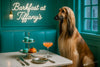 Afghan Hound by neon sign with teal macarons on two-tier stand, cocktail glass on marble table – Barkfast at Tiffany’s metal print