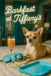 Chihuahua on a bed next to a peach cocktail glass, turquoise sleeping mask, pearl necklace and tray beneath Barkfast at Tiffany’s lettering