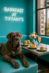 Grey Neapolitan Mastiff lounging on a turquoise banquette beside a café table with brioche rolls sliders and a peach cocktail under a Barkfast at Tiffany’s sign