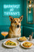 Norwegian Lundehund seated on a turquoise tufted banquette by a marble table with a slice of spinach quiche, two pear-topped toasts, and a peach cocktail under a neon Barkfast at Tiffanys sign