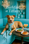 Pit Bull wearing a teal scarf lounging on a turquoise banquette beside a metal café table with arugula and tomato toast a spiral pastry and a pink cocktail