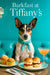 Rat Terrier wearing a turquoise scarf seated on a teal banquette beside a metal café table with a crumb-topped muffin, two mini egg salad sliders, and a peach cocktail beneath a crystal chandelier