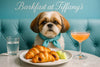 Shih Tzu wearing a turquoise scarf seated on a turquoise banquette beside a marble table with jam-filled croissants melon cubes a glass of water and a peach brunch cocktail