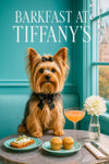 Silky Terrier wearing a black bow tie topknot seated at a gray café table with herby whipped cheese toast two muffins a peach brunch cocktail and a white bloom by a window