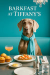 Weimaraner wearing an aqua scarf seated on a teal banquette beneath a glowing neon café sign
