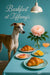 Whippet standing next to a teal table set with croissants grapefruit orange slices a pink peony in a glass vase and a cocktail under a pendant lamp