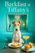 Wire fox terrier seated at a metal table with egg-topped brioche two golden muffins a peach cocktail and silver utensils in front of a teal display with chandelier and gift boxes
