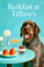 Wirehaired pointing griffon seated next to a teal table with smoked salmon sliders a layered berry parfait a peach cocktail and white flowers in bud vases against a Tiffany-blue banquette