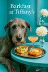 Wolfhound seated next to a teal table with a spinach tart puff pastry and a peach cocktail beside a white dahlia in a bud vase