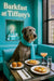 Wolfhound wearing a teal scarf seated at a Tiffany-blue banquette with two golden muffins two slices of brioche topped with egg salad and apricot slices a peach cocktail and a glass of water on a metal table