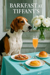 American Foxhound wearing a Tiffany-blue scarf seated at a turquoise table with fig-topped toast, two brioche buns, and a peach cocktail by a marble wall with mirror and white peony
